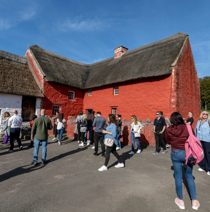 Group of people on a tour of the historic building in an open air museum.