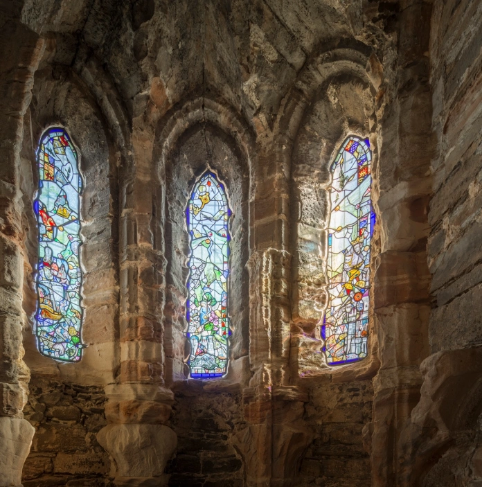 Three stained glass windows in a castle.