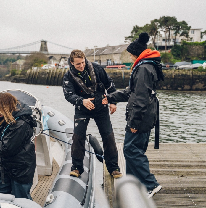 Group of ladies climbing on board a fast speed boat.