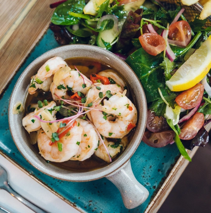 Prawns in a broth with a side salad, and fries.
