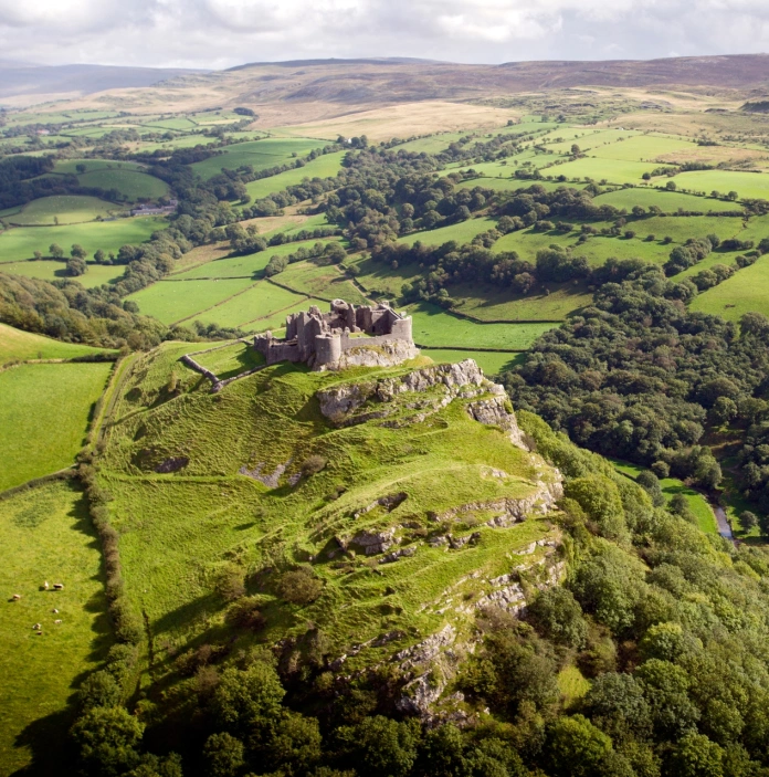 A castle on a hill overlooking the mountainous countryside.