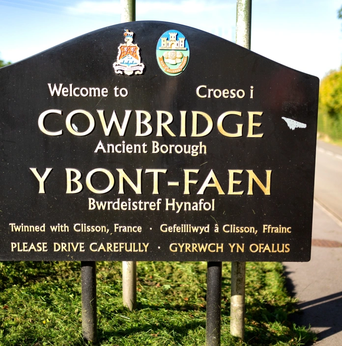 A welcome sign leading to a town.