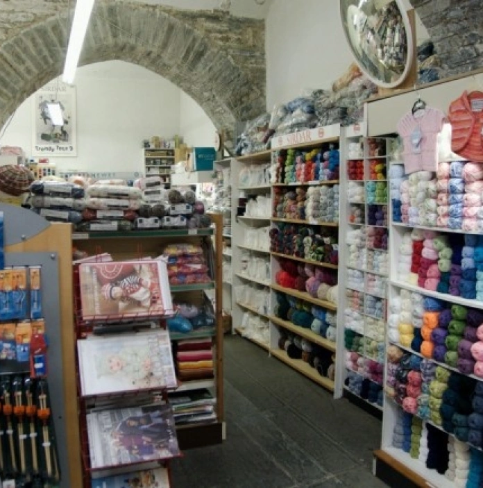 Wools, sewing and knitting equipment on shelves in a shop.