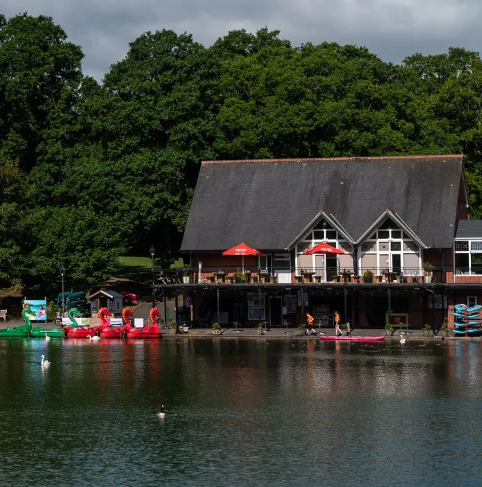 Boats on a lake near a boating house.