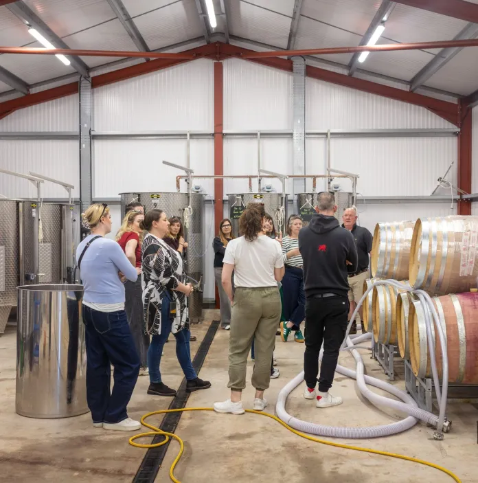 Group of people inside a winery at a vineyard.