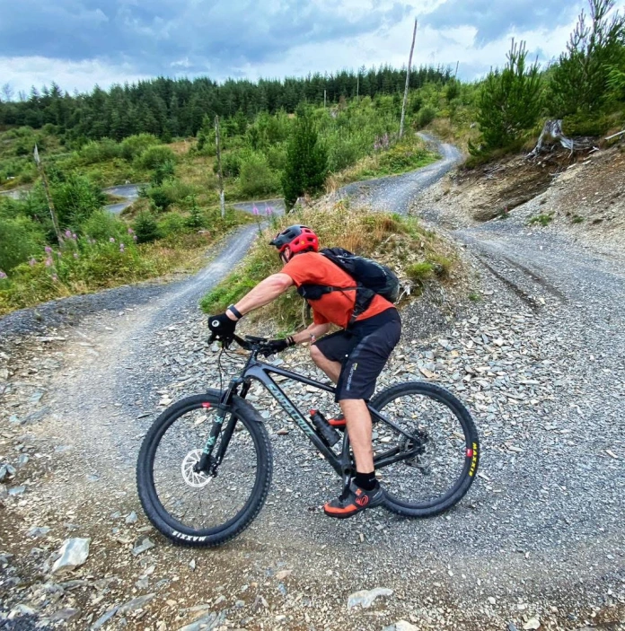 A cyclist heading down a mountain on a dedicated mountain bike trail.