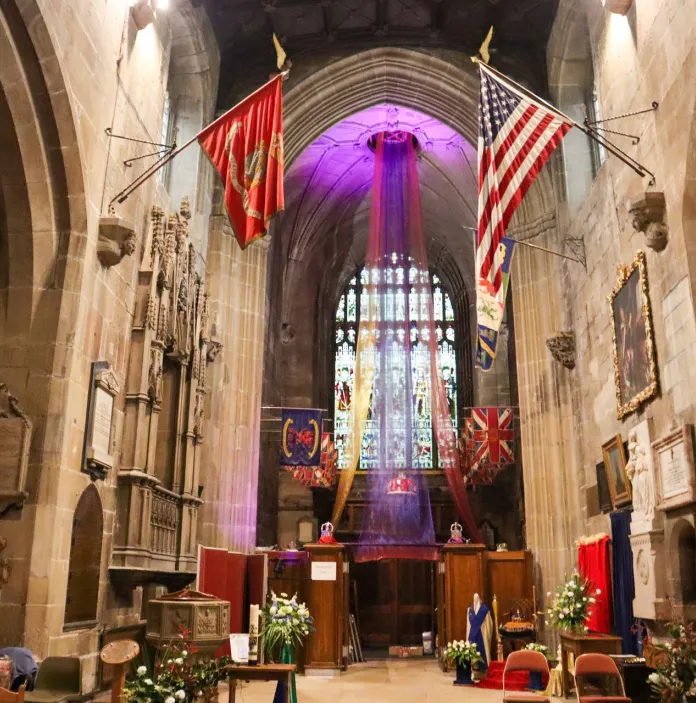The aisle leading to a stained glass window in a church