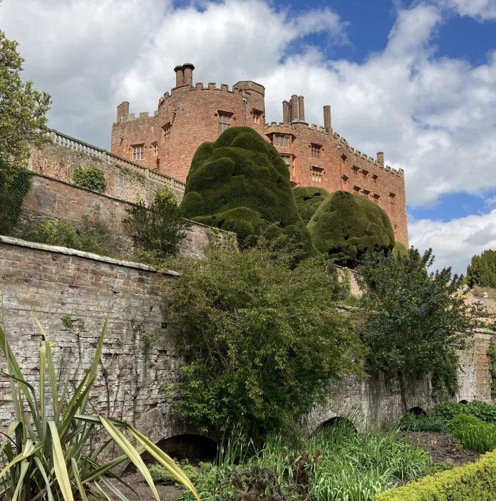 A castle sitting above the garden walls.