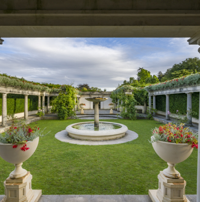 Pompeian garden with colonnades and lawns surrounding the central fountain.