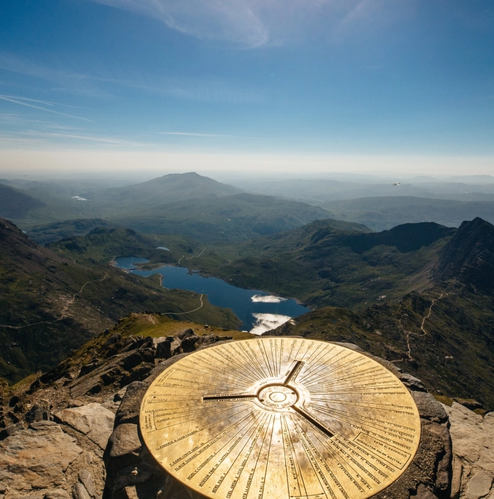 Trig point on top of Snowdon looking over the lakes.