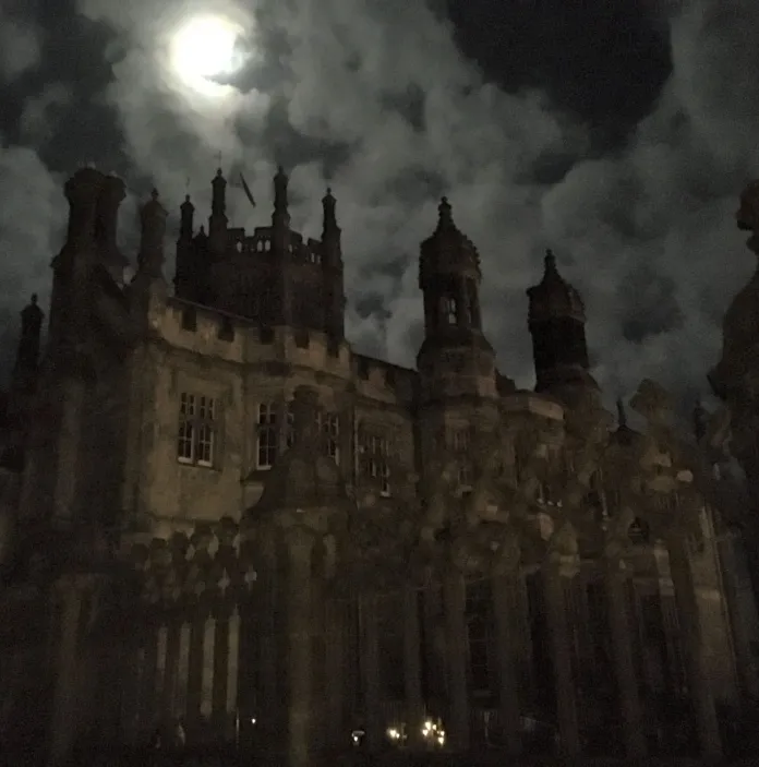 A castle at night with the moonlight shining down on it.