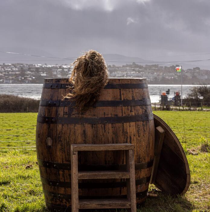 A women sitting in a barrel overlooking the strait.