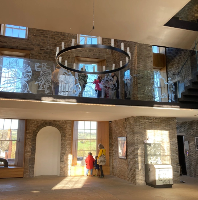 Inside a restored castle with large windows looking out to the countryside.