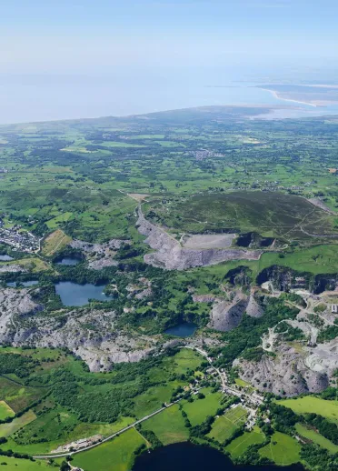 An aerial shot of a slate quarry valley, fields and reservoirs.
