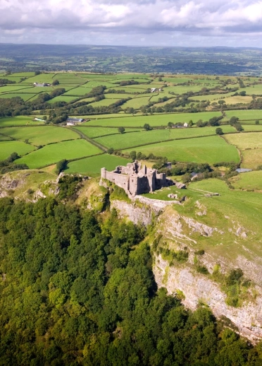 A castle on a large hill surrounded by countryside.