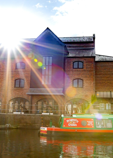 Narrowboat on canal in front of Theatr Brycheiniog