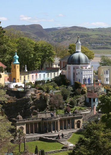 A view of Portmeirion village and gardens beyond the trees.
