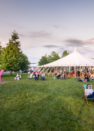 People sitting around a festival tent.