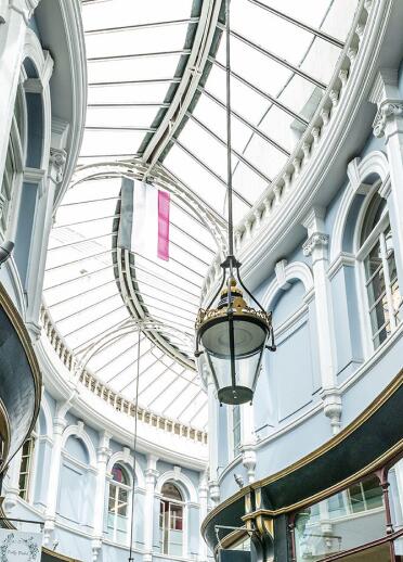 Looking up to the glass roof and lighting in a Victorian shopping arcade.