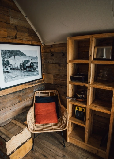 Inside a glamping tent with wooden panels, kitchen lounge and bedroom