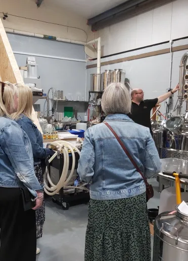 Group of people of a tour of a distillery.