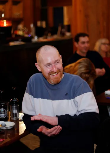 A man in the audience laughing during an entertainment evening.
