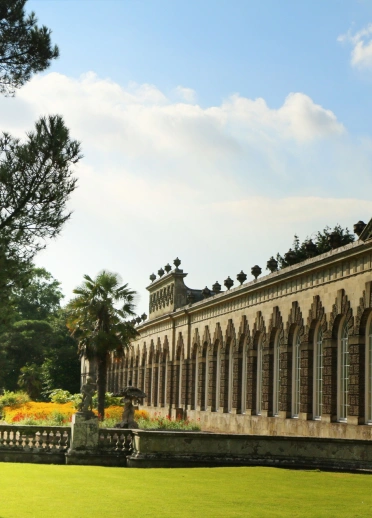 A large building surrounded by gardens in a country park.