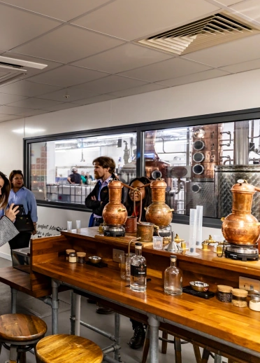 Group of people in a workshop at a gin making distillery.