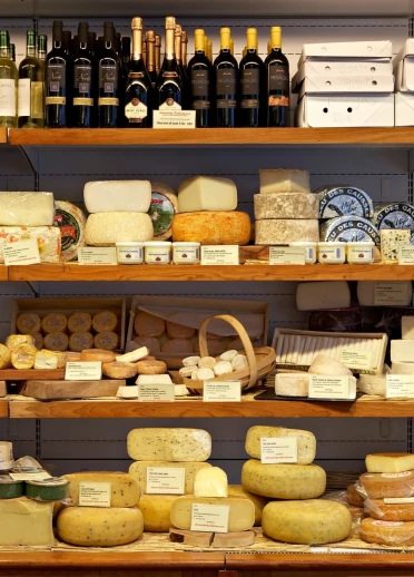 Cheeses on a shelf in a shop.