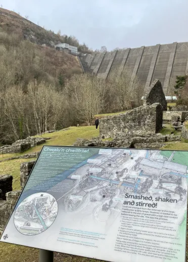 Information board showing the former lead mines with a dam beyond.