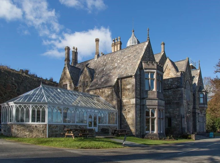 A grand house with a conservatory.