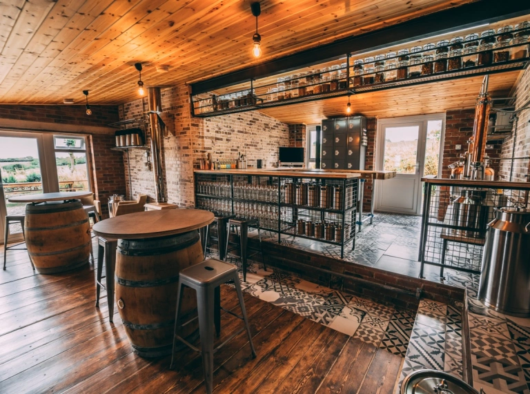 A room with kegs as tables and vats in the background.