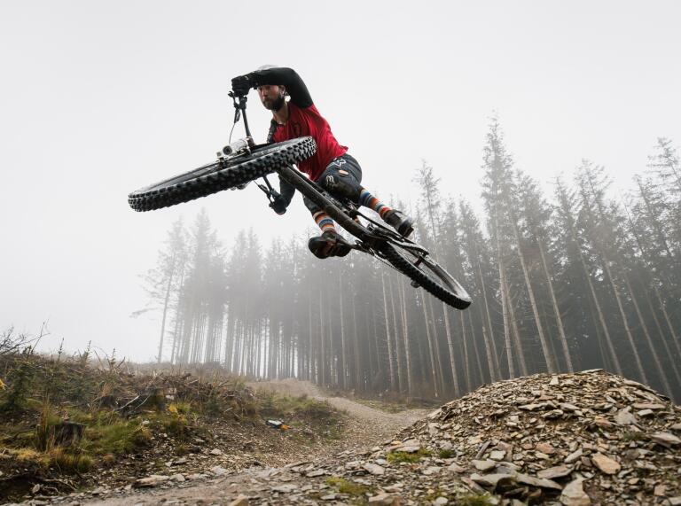 A mountain biker flying high on a downhill track.