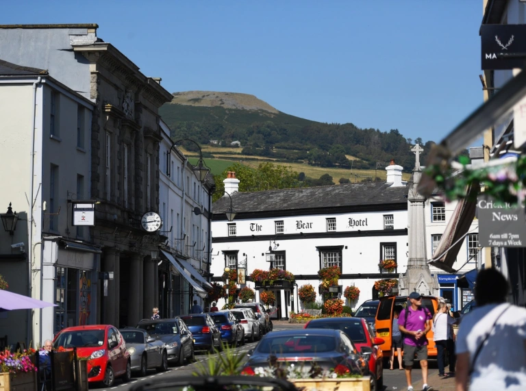 A hotel at the end of a street full of shops and people.