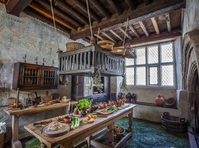 Inside the kitchen with vegetables to prepare on the table at Plas Mawr historic house.