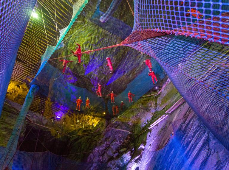 People on bouncing nets in a cavern.