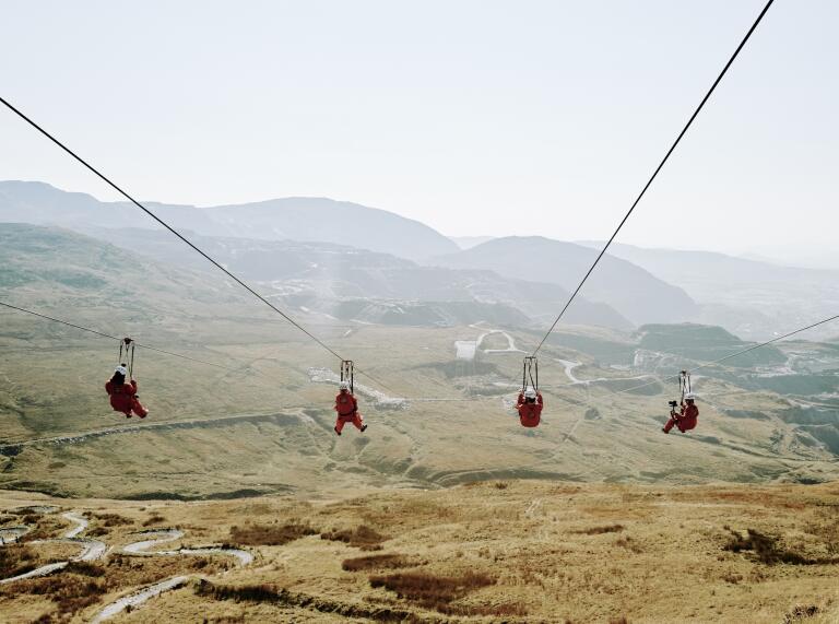 Four people travelling down a zip wire.
