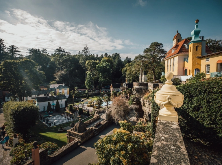 View of a garden and giant chessboard from a balcony in an Italianate village.