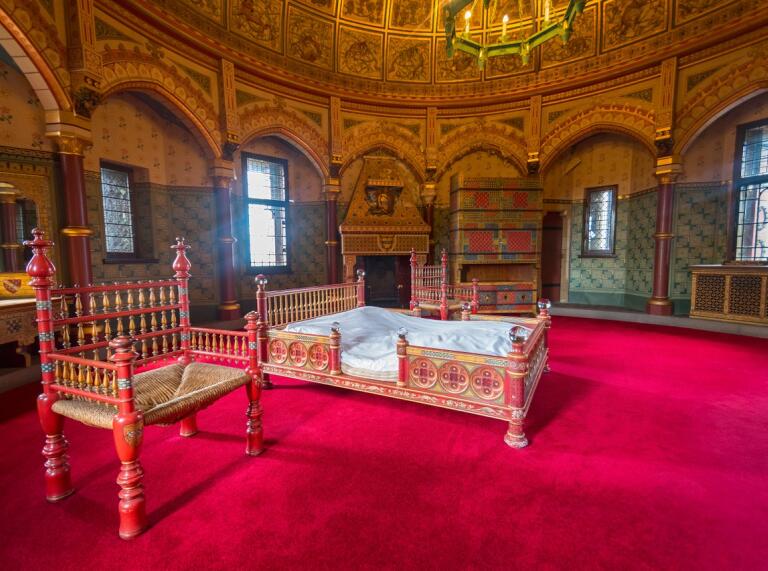 An ornate bedroom in a large round castle tower.