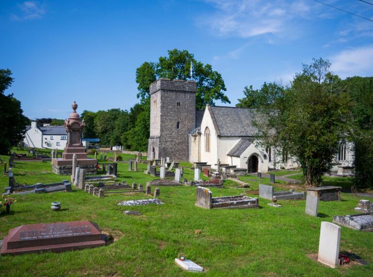An historical church and graveyard on a sunny day.