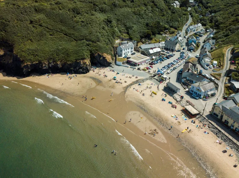 An aerial shot of Llangrannog beach, sea and surrounding buildings.