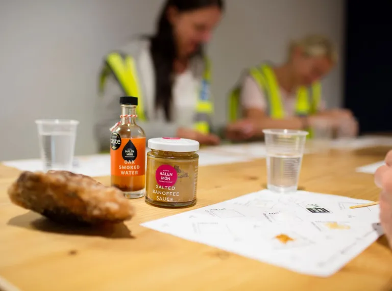 People on a tour of a salt factory sitting around a table tasting salt.