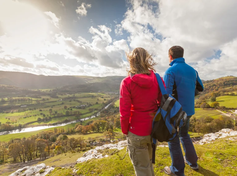 Couple walking on a path overlooking the valley below.