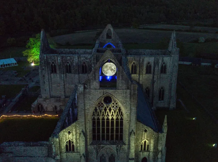 The ruins of an abbey in the eerie glow of night.