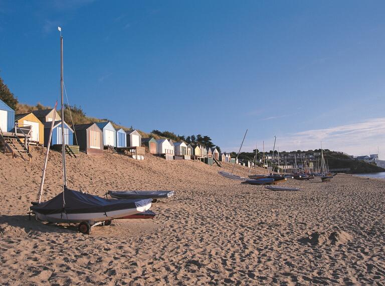 Abersoch beach with boats and beach huts. 
