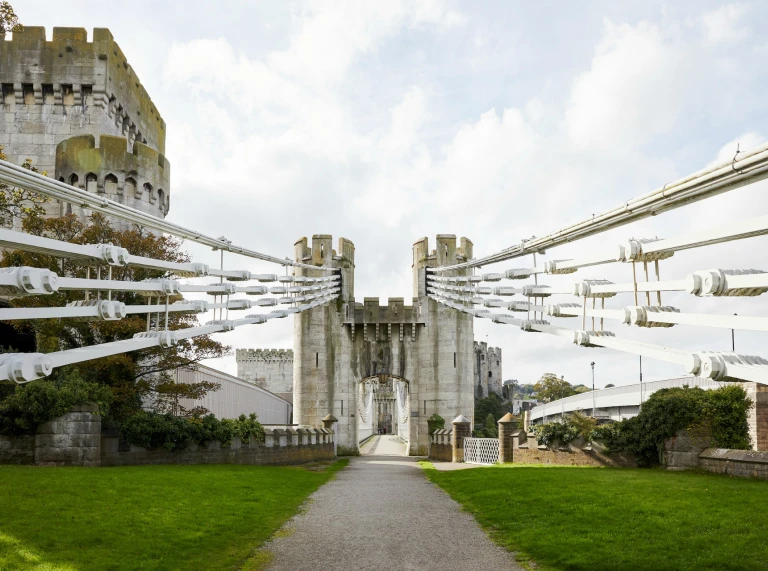 The entrance to a castle between the suspension cables of the bridge.