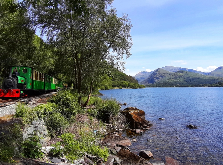 steam engine with carriages passes lake.