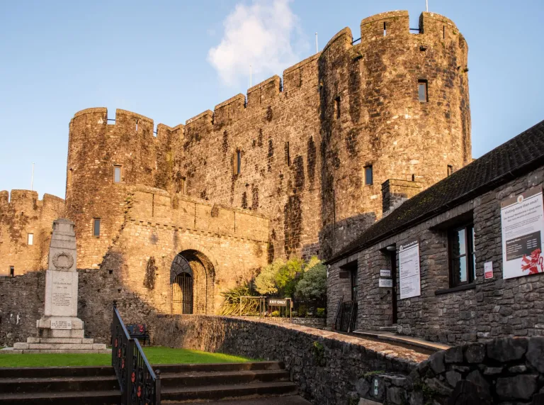 The entrance to a castle with a cenotaph positioned on the lawn.