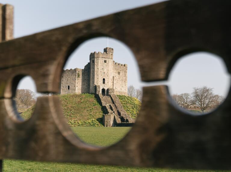View of a castle through medieval stocks.