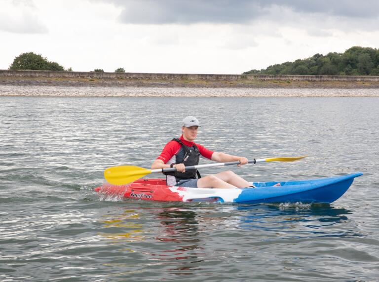 A man kayaking on a lake.